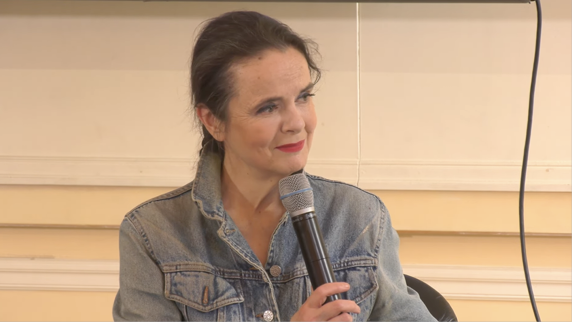 A woman is sitting in a chair and holding a microphone.

Contenu généré par l’IA